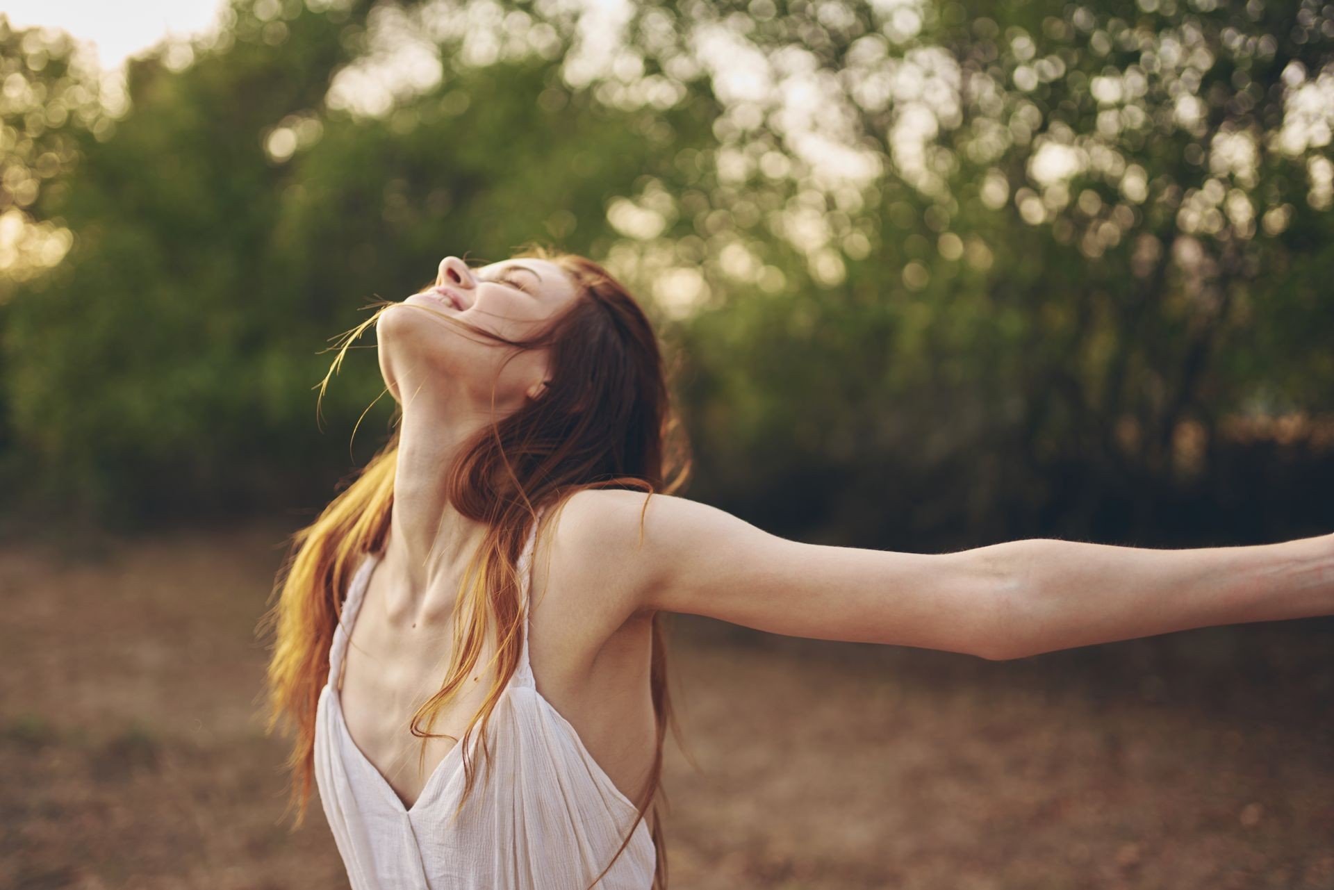 Woman spreads her arms against nature                               